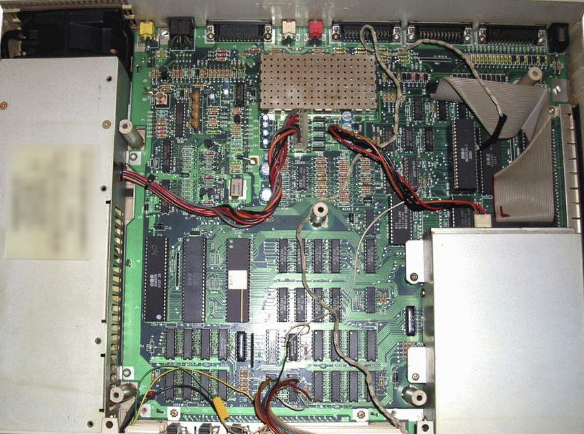 Innenansicht des dokumentierten Commodore Amiga 1000 mit Hauptplatine, Netzteilbereich, Abschirmung, Laufwerksbereich und Kabelwegen