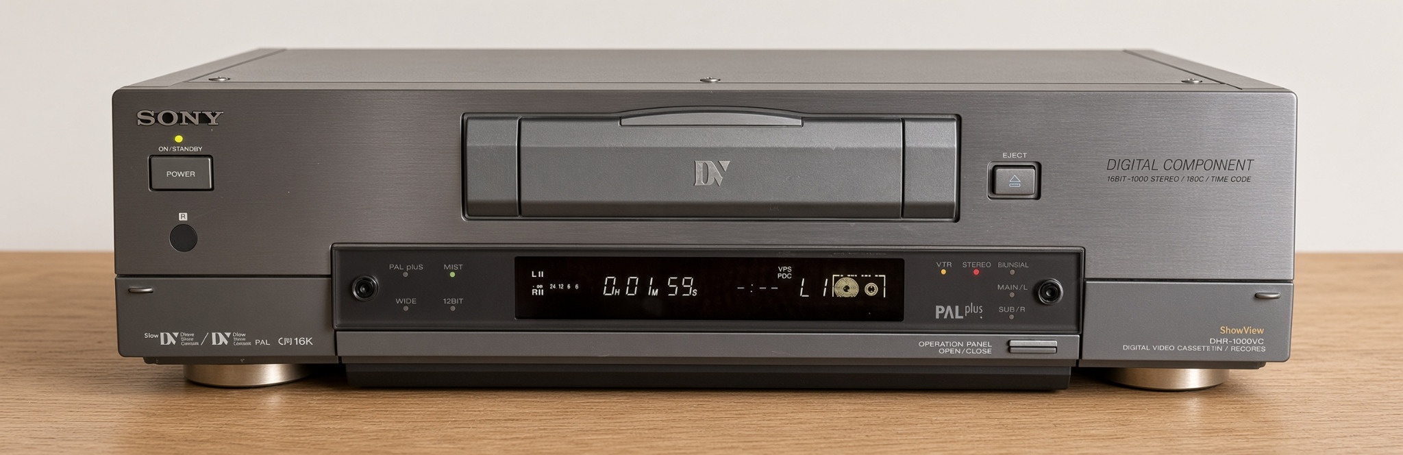Sony DHR-1000VC in geschlossener Frontansicht auf einer Holzplatte mit DV-Kassettenfach und Display