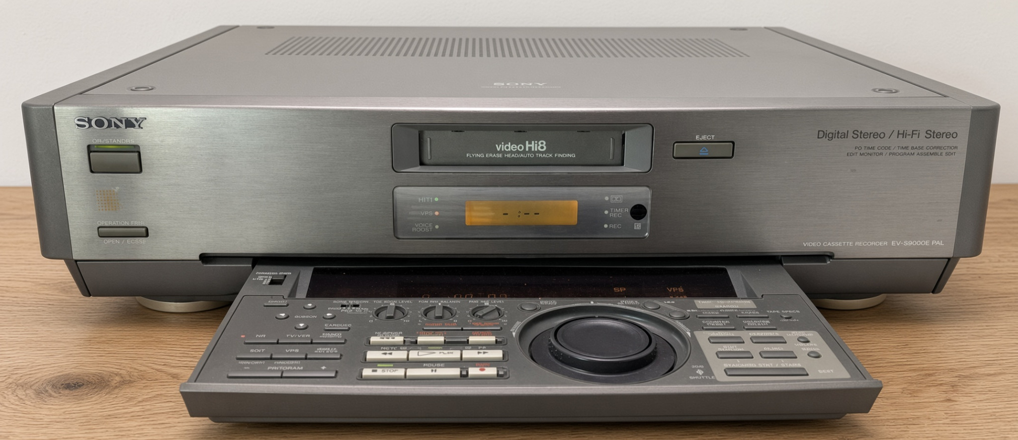 Sony EV-S9000E von vorne auf Holzplatte mit ausgeklappter Bedieneinheit, sichtbarem Jog/Shuttle-Rad und der Beschriftung Digital Stereo beziehungsweise Hi-Fi Stereo